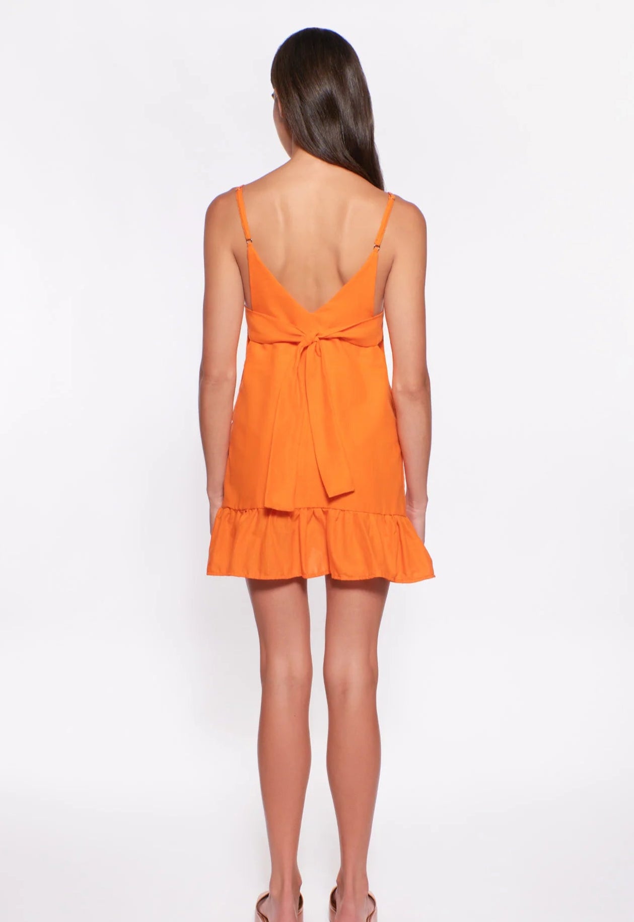 Short tiered dress with adjustable straps and ties in the back in orange