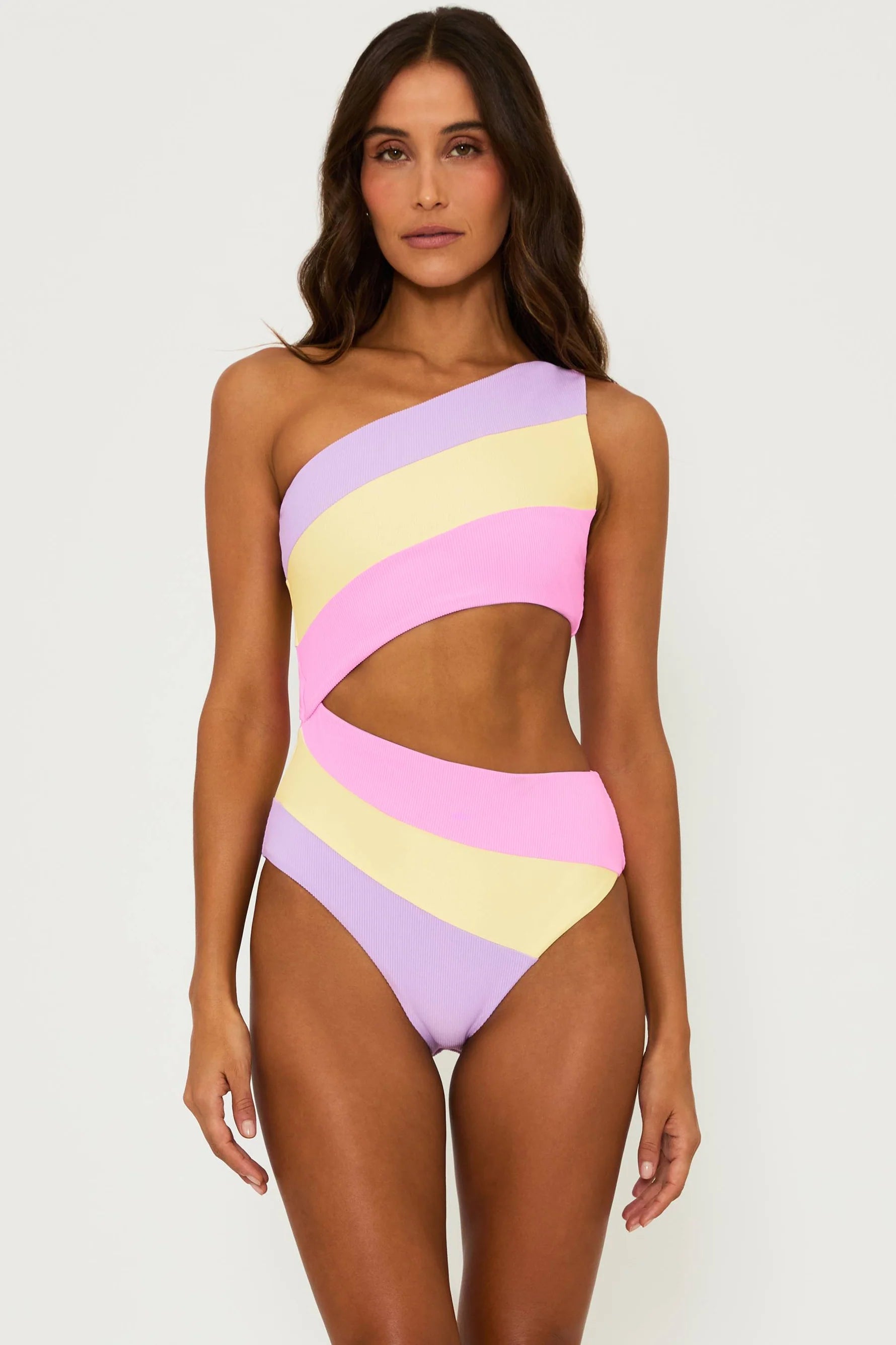 Asymmetric one piece with one shoulder strap and side cutout in pink, yellow, and lavender color block