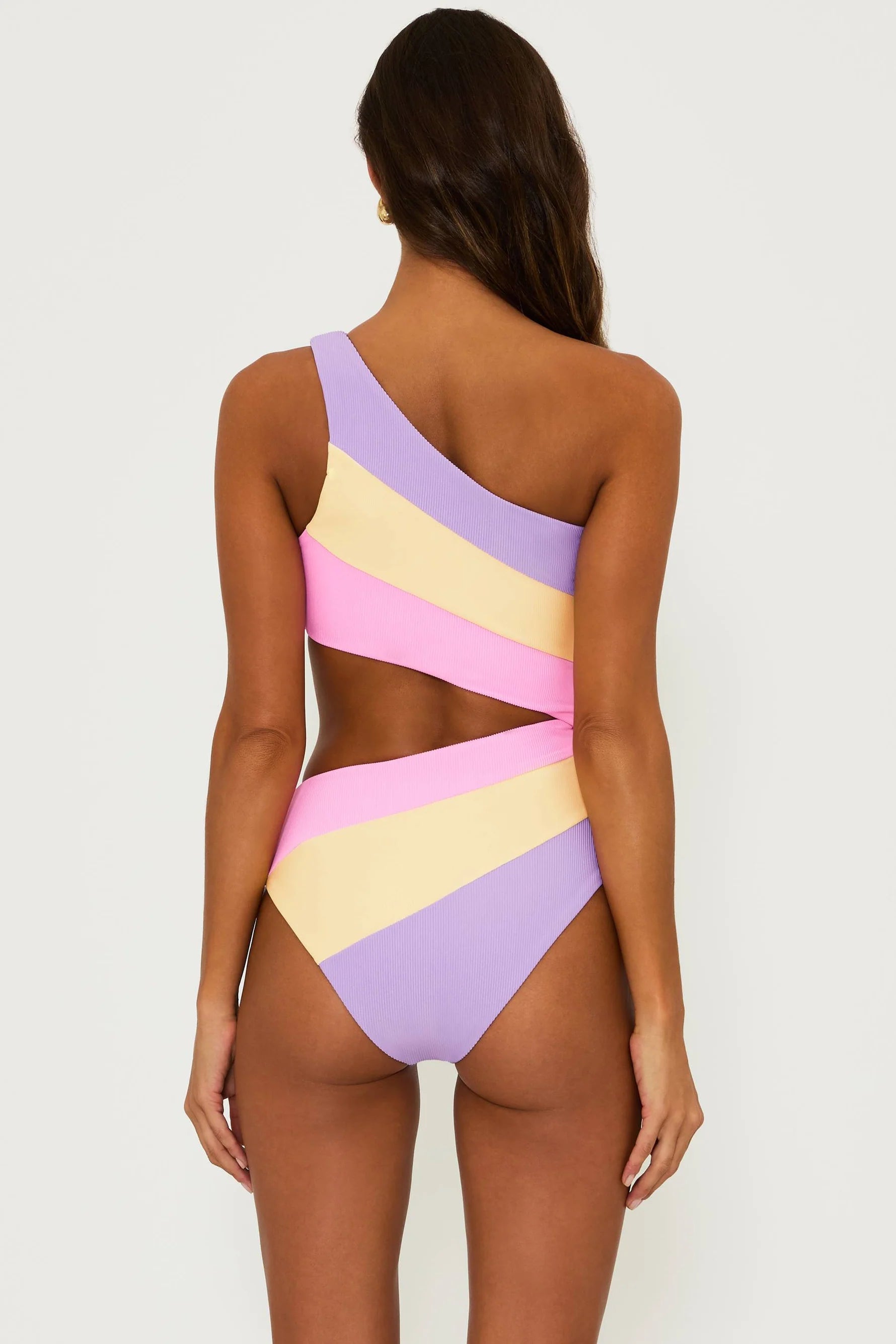 Asymmetric one piece with one shoulder strap and side cutout in pink, yellow, and lavender color block