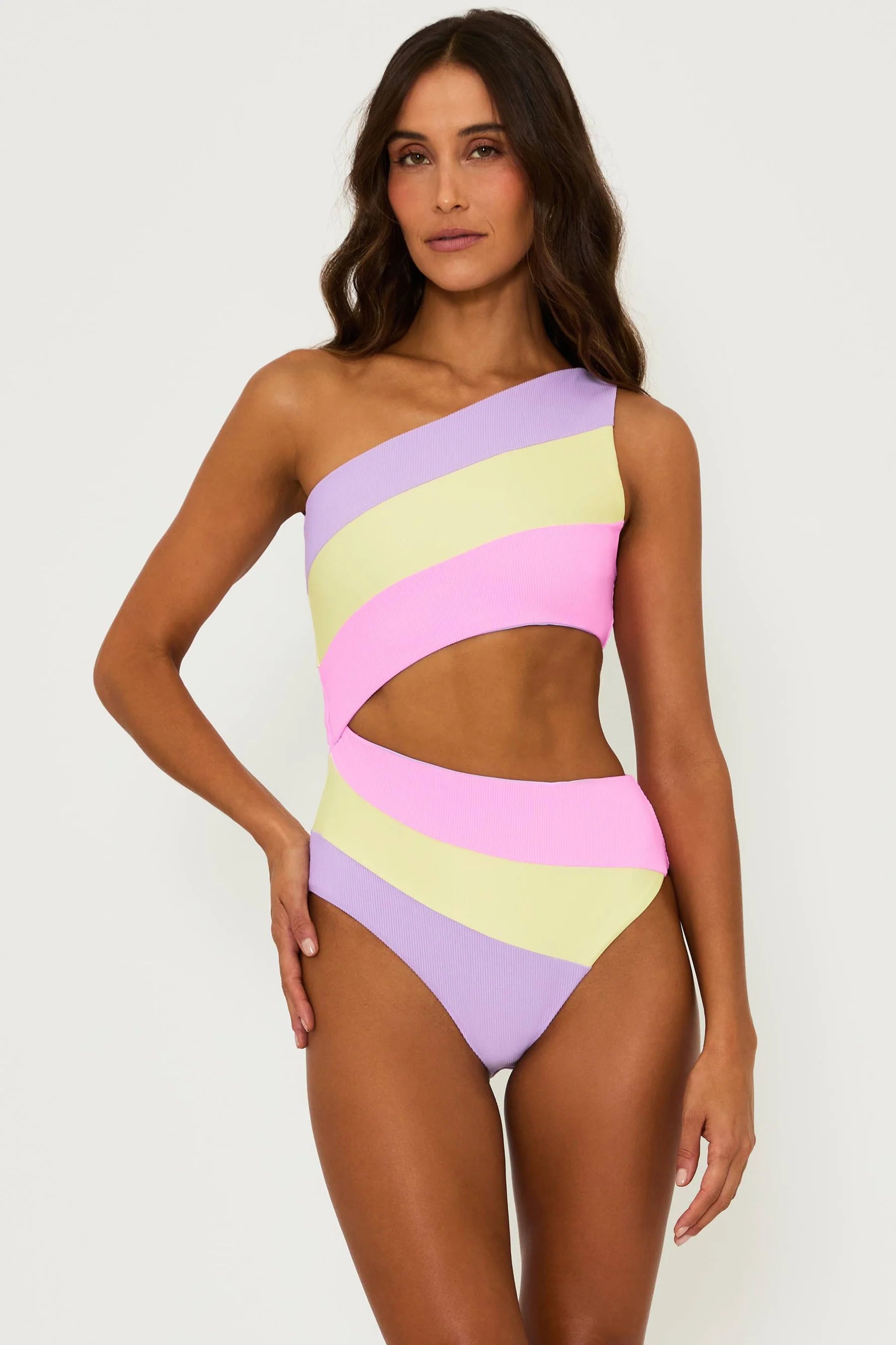 Asymmetric one piece with one shoulder strap and side cutout in pink, yellow, and lavender color block