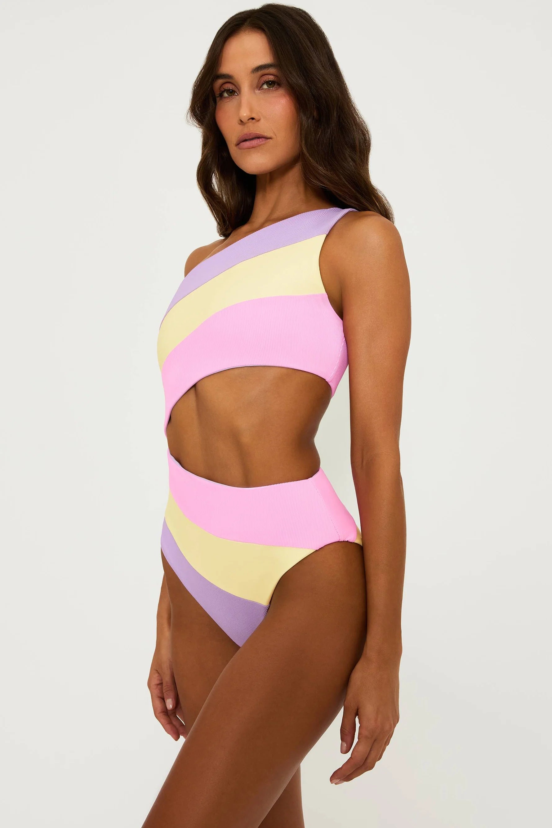 Asymmetric one piece with one shoulder strap and side cutout in pink, yellow, and lavender color block