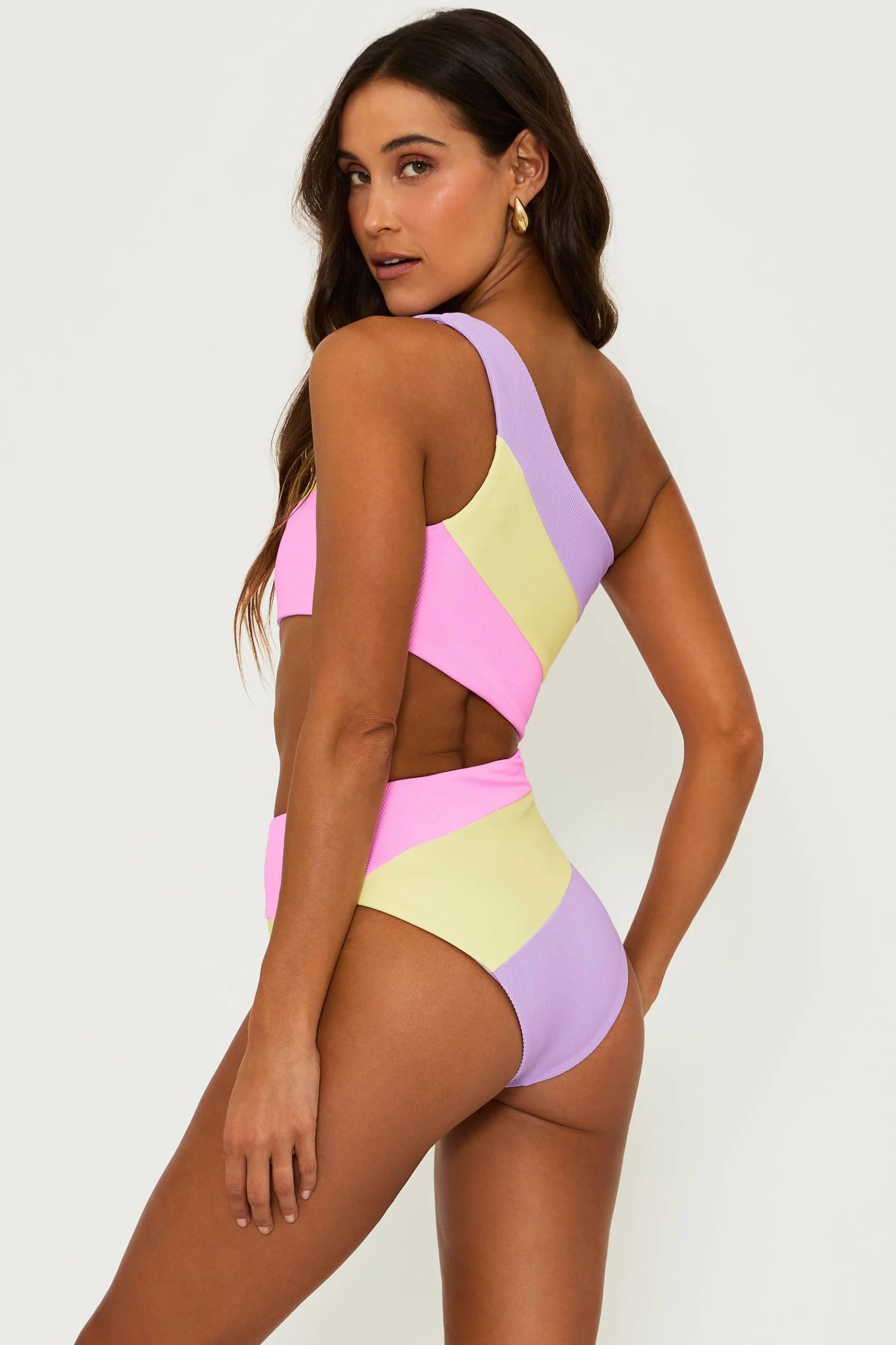 Asymmetric one piece with one shoulder strap and side cutout in pink, yellow, and lavender color block