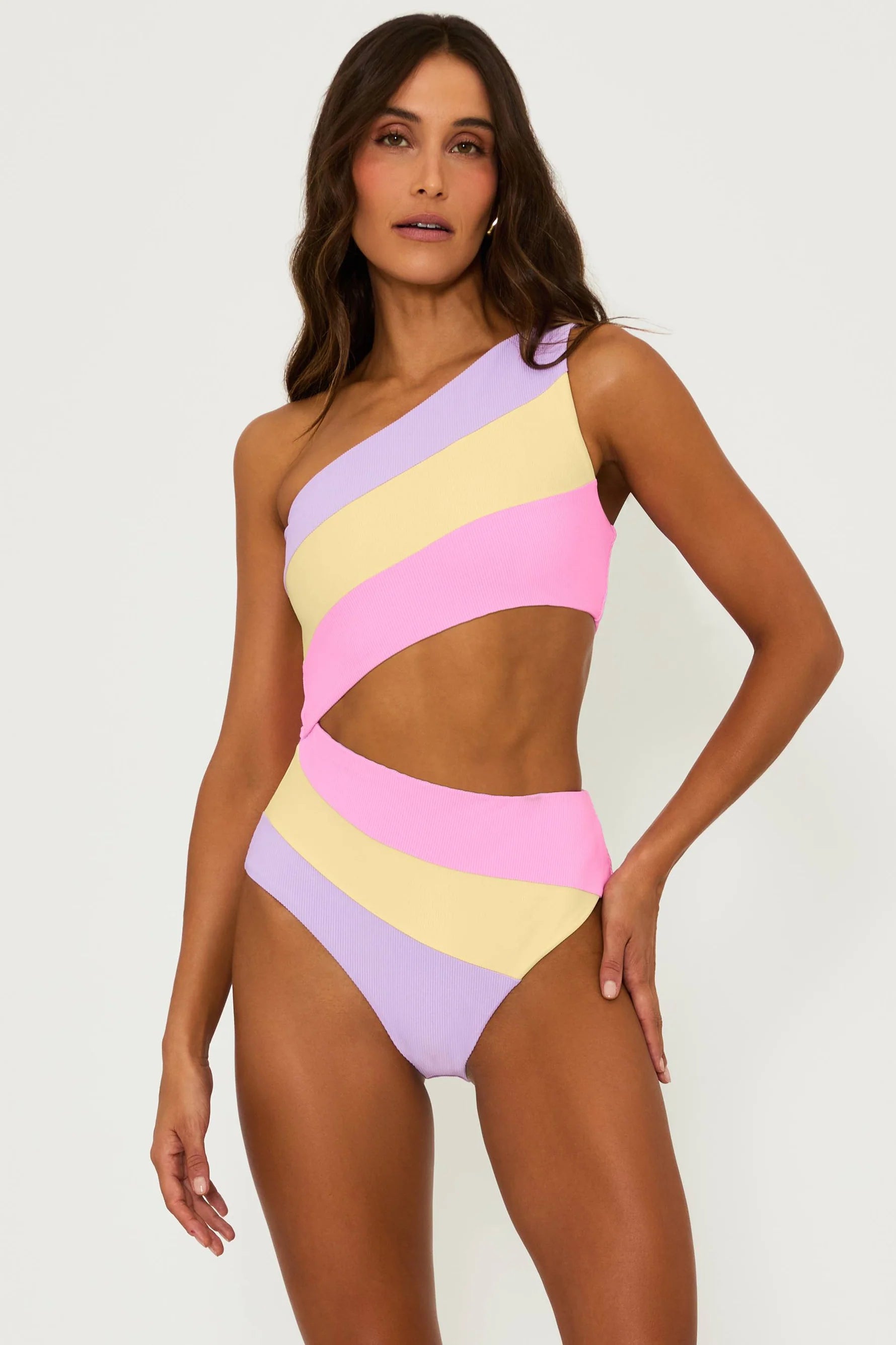 Asymmetric one piece with one shoulder strap and side cutout in pink, yellow, and lavender color block