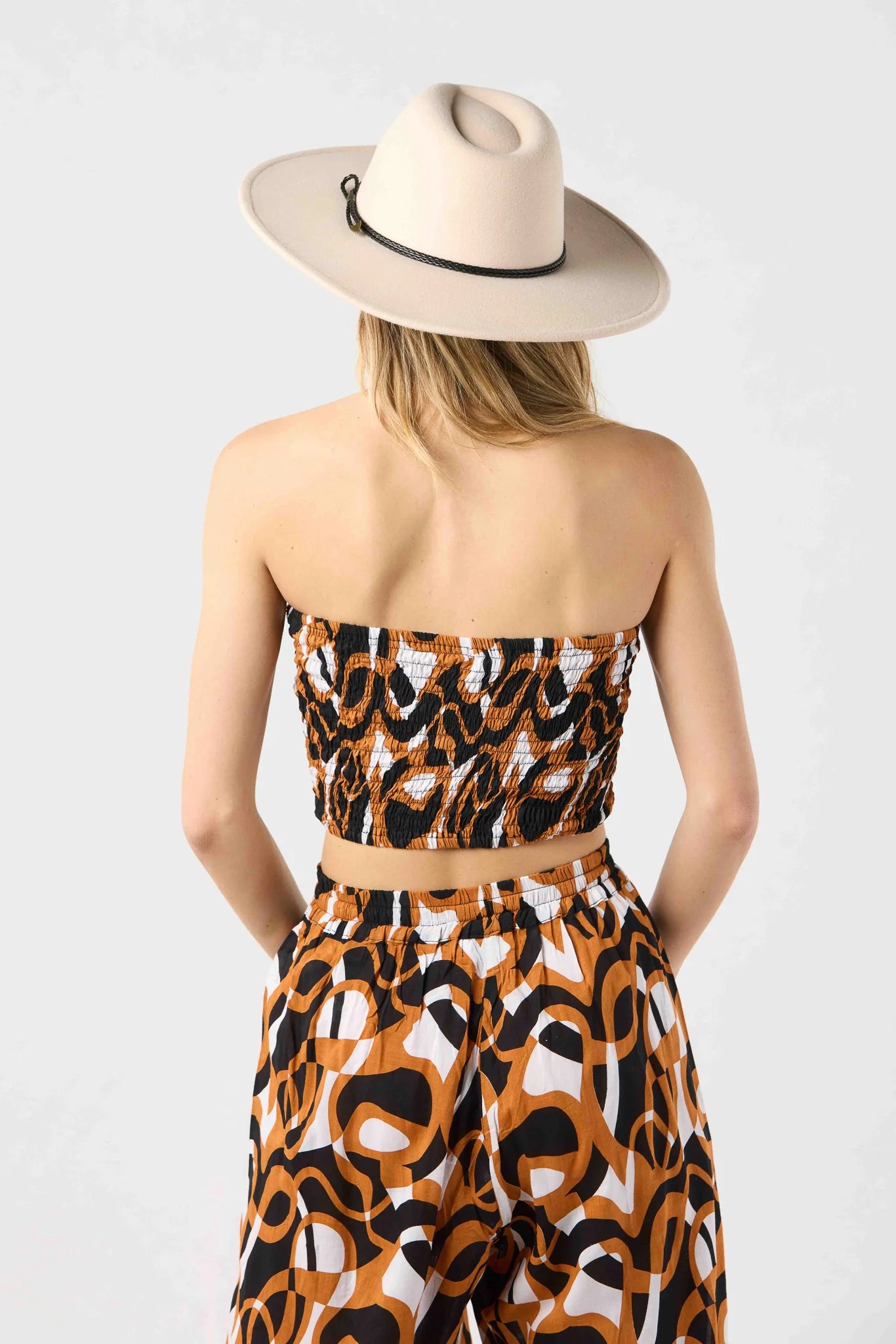 Strapless smocked crop top in brown and black print