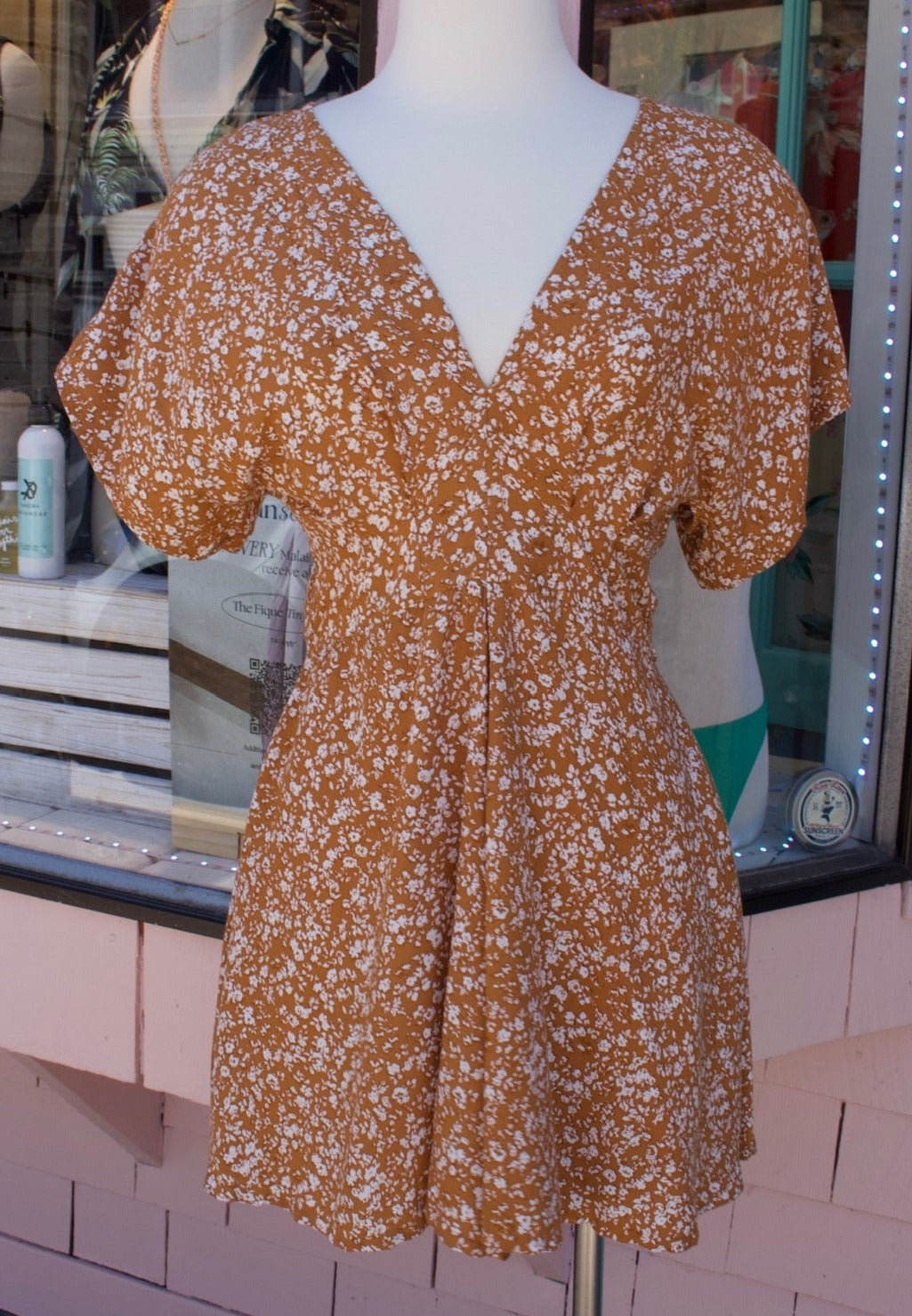Short sleeve romper in Rust with white flower print.