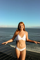 Ruched front top with criss cross strings and a tie in the back. Available in White