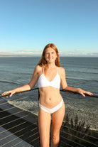 Ruched front top with criss cross strings and a tie in the back. Available in White