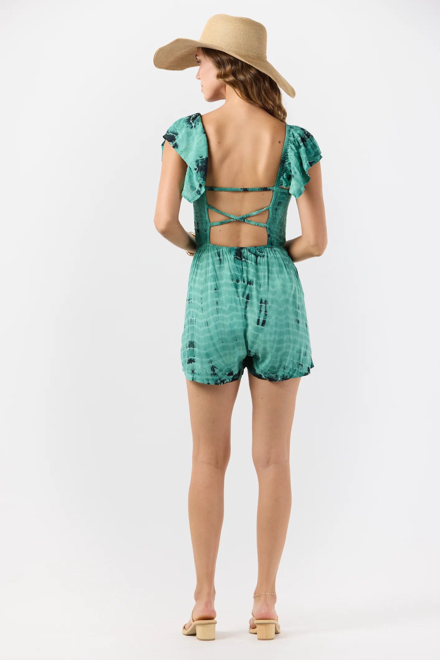 Tie dye romper with short ruffled sleeves and a tie front with tassels