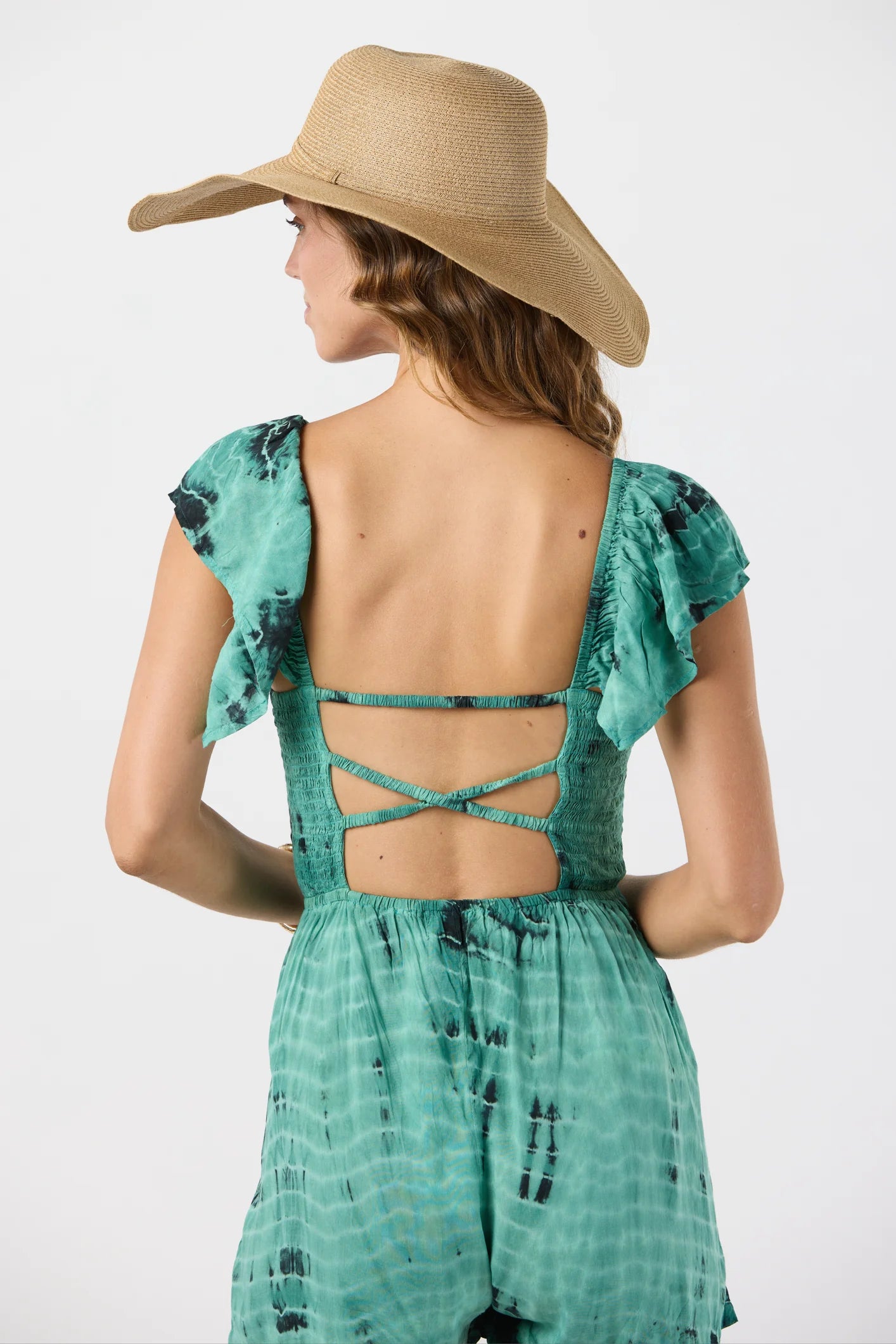 Tie dye romper with short ruffled sleeves and a tie front with tassels