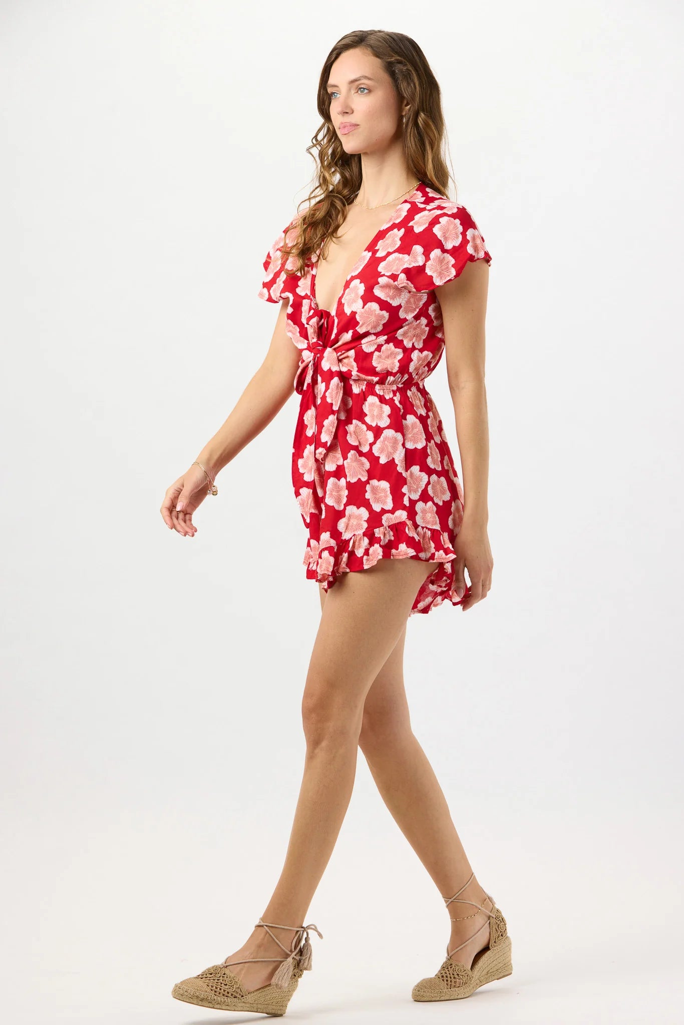 Red floral print romper with a plunging v-neckline and a tie front