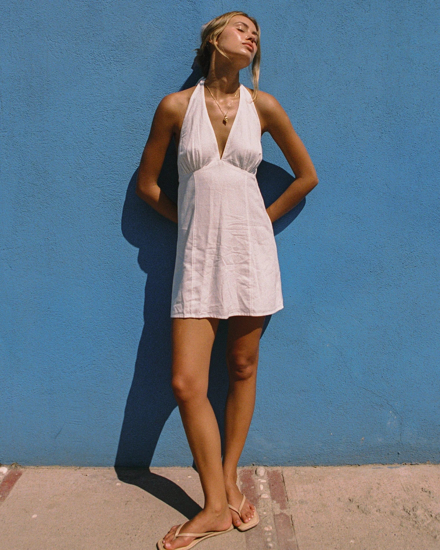 V-neck sleeveless mini dress with halter tie behind the neck in Cream