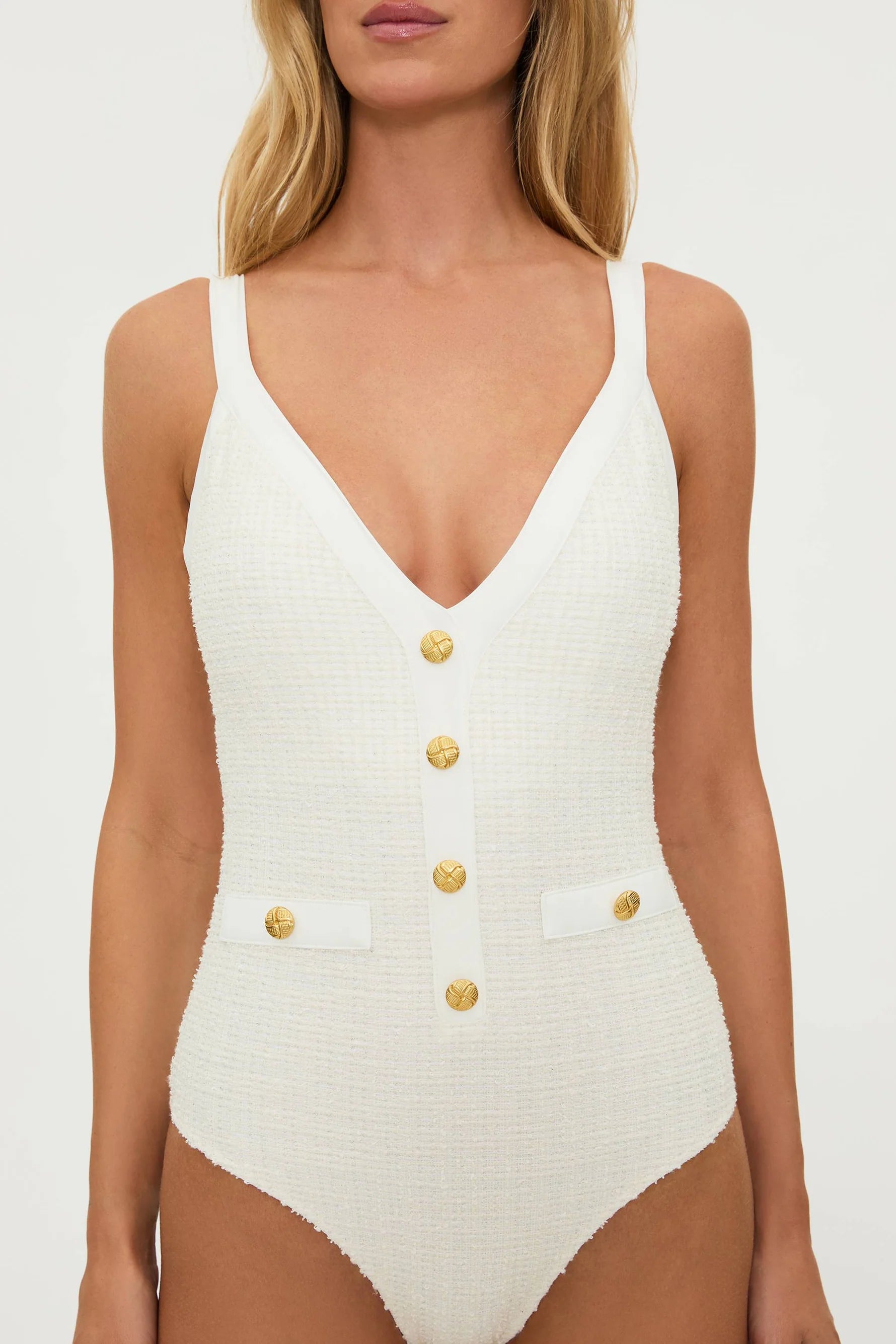 Plunging ivory one piece with decorative gold buttons