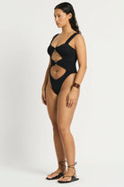 Black one size one piece with front cutouts, ring details, and minimal coverage in the back