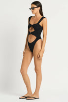 Black one size one piece with front cutouts, ring details, and minimal coverage in the back