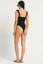 Black one size one piece with front cutouts, ring details, and minimal coverage in the back