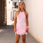 High neck knit mini dress with a halter tie and decorative beads and shells in pink and white.