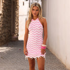 High neck knit mini dress with a halter tie and decorative beads and shells in pink and white.