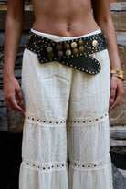 Wide black leather belt adorned with coins and studs