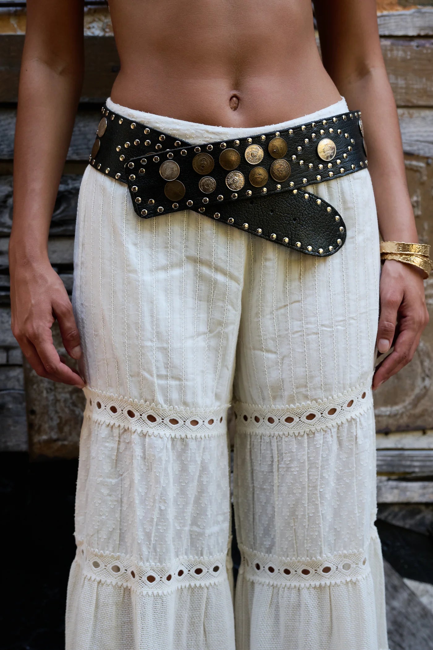 Wide black leather belt adorned with coins and studs