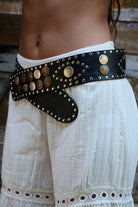 Wide black leather belt adorned with coins and studs
