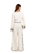 White top with long bell sleeves and blue and yellow floral embroidery
