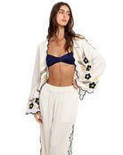 White top with long bell sleeves and blue and yellow floral embroidery