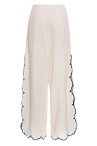 White wide leg pants with elastic waistband and blue and yellow embroidered floral print