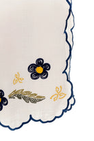 White wide leg pants with elastic waistband and blue and yellow embroidered floral print