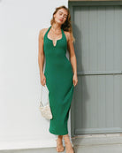 Green body hugging midi dress with a halter neckline and u bar front