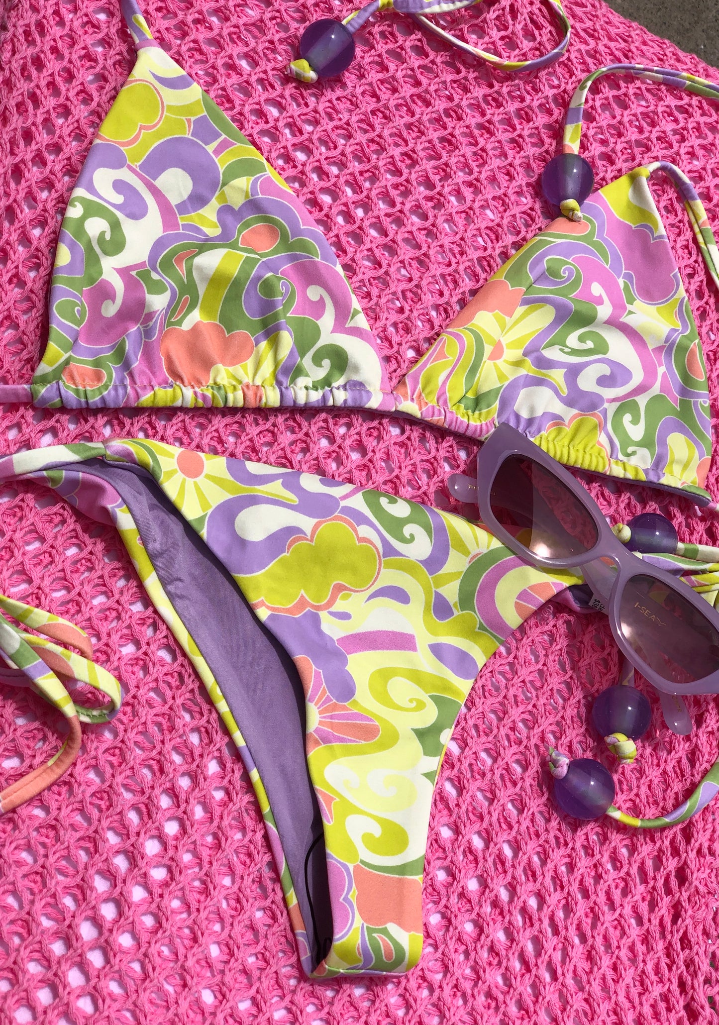 green, purple, and pink swirl print triangle bikini top and matching tie side bottoms