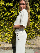 Bamboo pants with decorative buttons down each side in Cream.