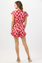Red floral print romper with a plunging v-neckline and a tie front