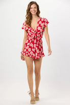 Red floral print romper with a plunging v-neckline and a tie front
