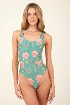 Shimmery scoop neck one piece with rings on the front of both shoulder straps. Available in green with pink floral print