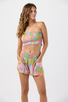 Smocked sleeveless crop top with ruffled edges in a colorful floral print