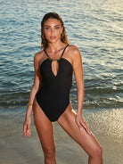 Black one piece with a front keyhole cutout and gold hardware