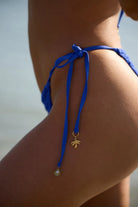 Skimpy crochet bottom with tie sides adorned with gold shells. Available in Cobalt.