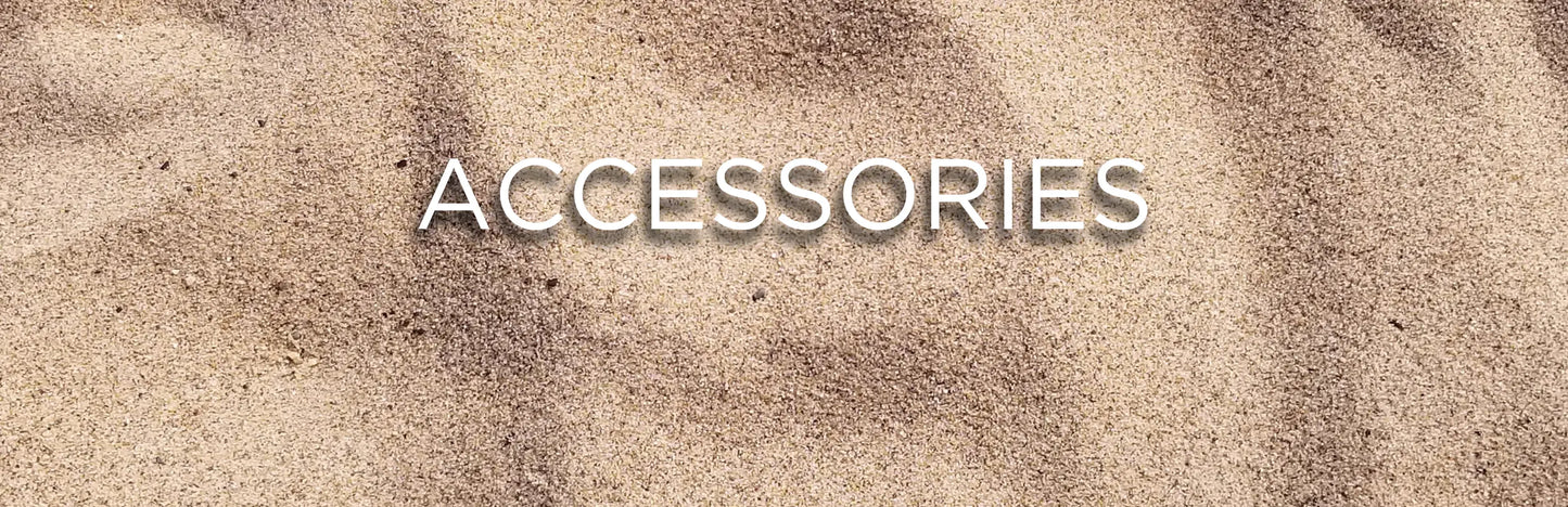 Promotional banner with the word 'ACCESSORIES' in white text over a close-up of a sandy beach background.