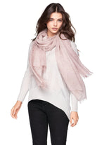 Woman wearing a light pink scarf on a white background
