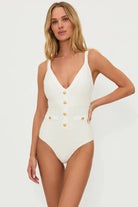 Plunging ivory one piece with decorative gold buttons