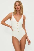 Plunging ivory one piece with decorative gold buttons