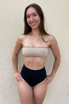 nude bandeau bikini top and black high waisted bikini bottoms 